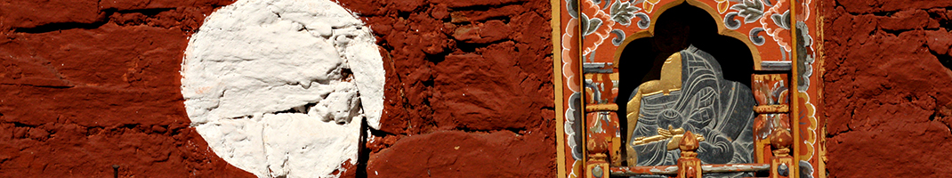 A buddhist nitch with a buddha carving in it on a red background