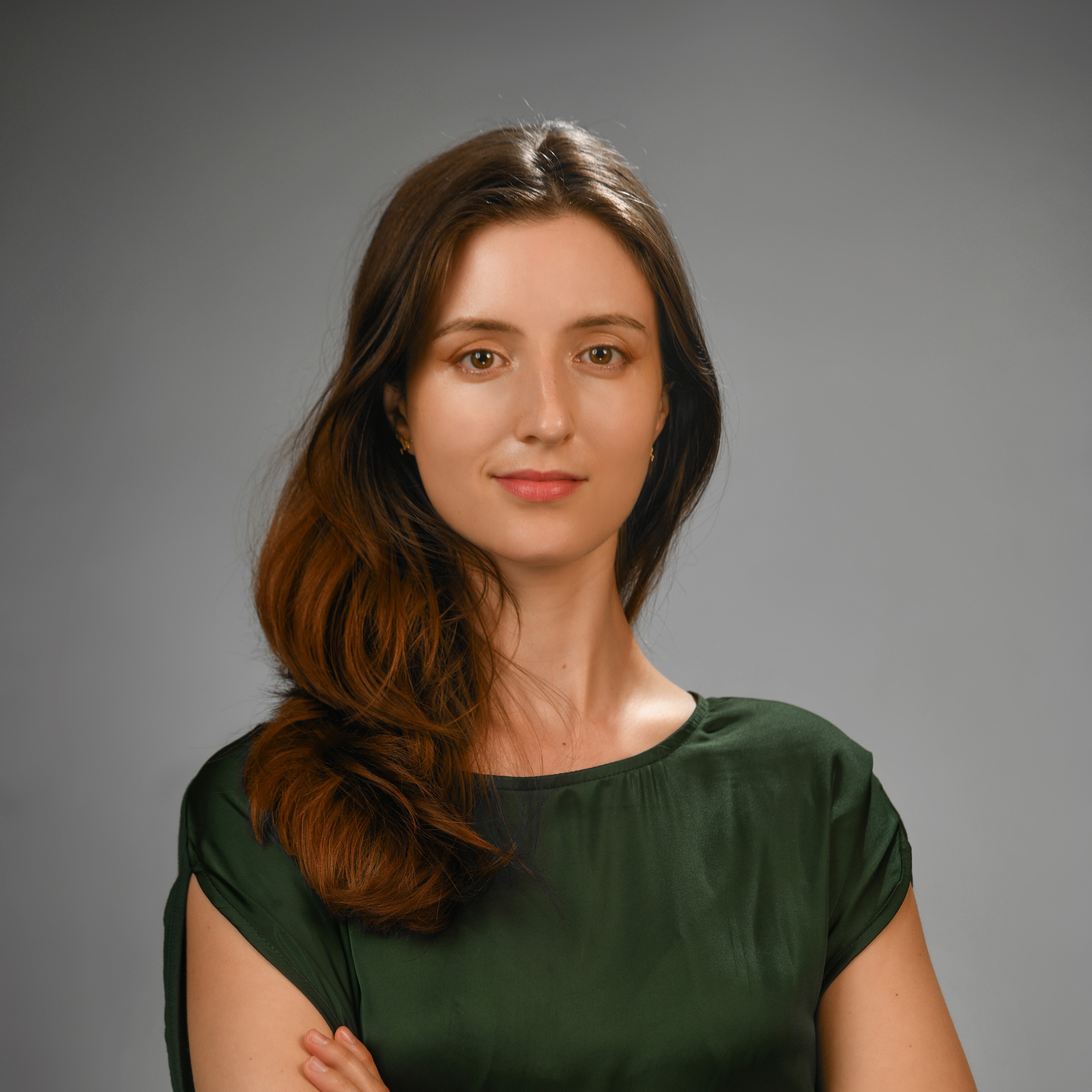 Woman against a neutral background with long hair: a professional headshot.