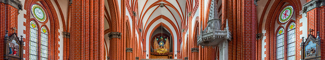 Inside of a church down the middle asile. Decorated in red brick with white walls