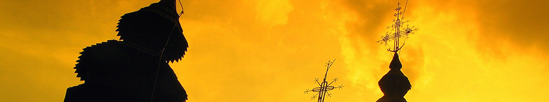 Silouette of wooden slovakian churches against a firey sky