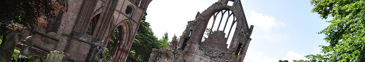 A ruined church abby in the uk: no roof, arches intact with sky between