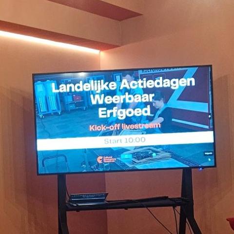 wall that says nationale bibliotheek and a screen that says Naitonal Action Day Resiliant Heritage in Dutch