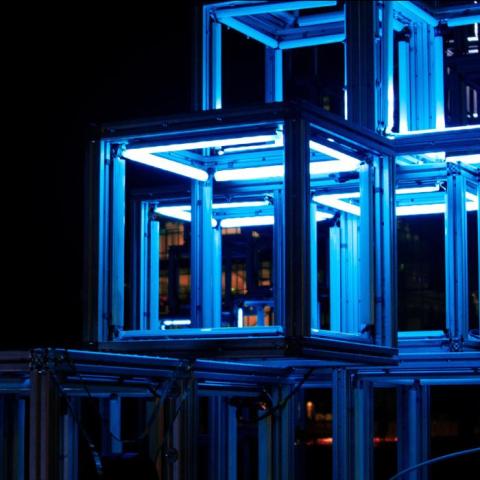 A series of lit up bokes that are implied to either be art or storage spaces for art
